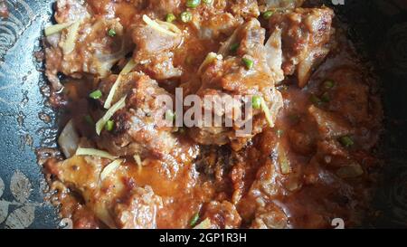 Piatto di carne, montone o curry di pollo in una ciotola guarnita con peperoncino e spezie. Cucina indiana pakistana tradizionale Foto Stock