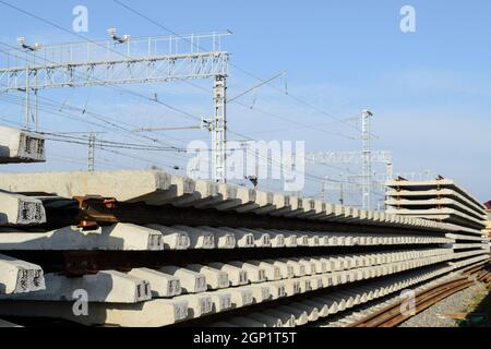 Nuove rotaie e traversine. I binari e le traversine sono impilate le une sulle altre. Il rinnovamento delle ferrovie. Ferrovia Strada per il treno. Foto Stock