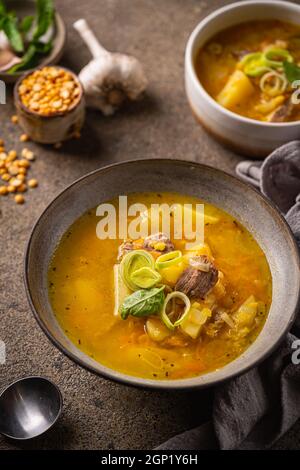 Primo piano di una ciotola di zuppa di piselli con pezzi di prosciutto e carne Foto Stock