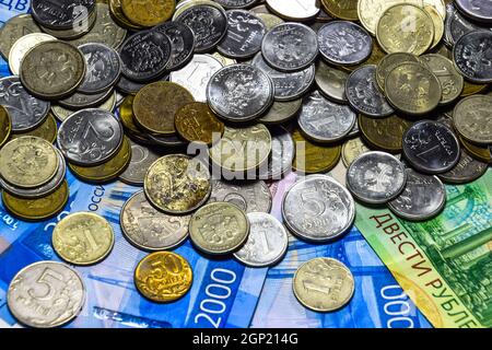 Federazione delle banconote e delle monete in euro. Una manciata di monete sul russo nuove banconote in tagli di 2000 e 200 rubli Foto Stock