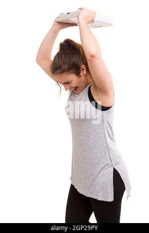 Concetto di dieta - Mad donna di distruggere la sua scala Foto Stock