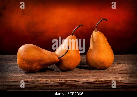 Tre grandi pere bosc gialle su un tavolo di legno di fienile e grunge sfondo Foto Stock