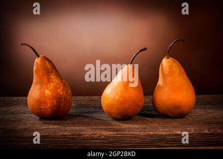 Tre grandi pere bosc gialle su un tavolo di legno di fienile e grunge sfondo Foto Stock
