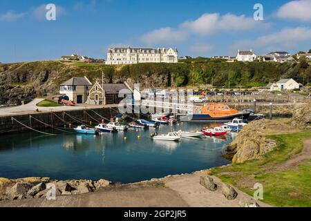 RNLI Lifeboat e piccole barche ormeggiate nel porto naturale nel villaggio di pescatori della costa occidentale. Portpatrick, Dumfries e Galloway, Scozia, Regno Unito, Gran Bretagna Foto Stock