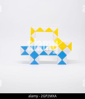 Auto giocattolo fatta di triangoli blu, giallo e bianco su sfondo bianco. Foto Stock