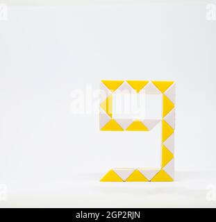 Lettera 'g' fatta di triangoli gialli e bianchi su sfondo bianco. Foto Stock