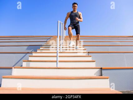 giovane uomo che corre al piano di sotto allo stadio Foto Stock