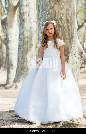 Ritratto a tutta lunghezza di ragazza carina in abito bianco in foresta. Foto Stock