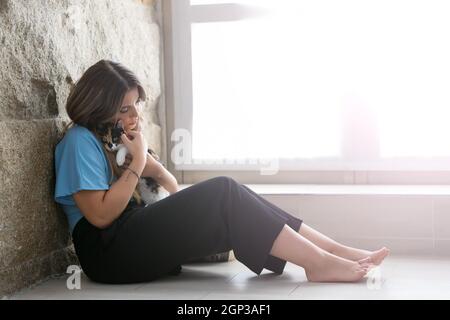 Chiusura del proprietario femmina mentre tiene il suo bel bianco e nero gatto a casa. Concetto di amore per gli animali, animali domestici, la cura e la tranquillità. Foto Stock