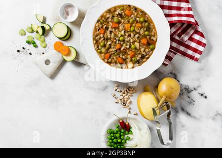 Minestrone italiano con verdure e fagioli su un tavolo bianco di marmo Foto Stock