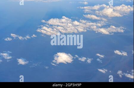 Soffici nuvole di cielo illuminate dal sole del pomeriggio, come visto dall'aereo che sorvola. Foto Stock