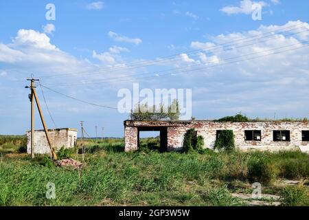 Le rovine della vecchia fattoria. Coni con base a colonna della parete. Abbandonata e di edifici in rovina. Foto Stock