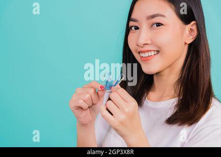 Attrezzi di ritegno dei denti dopo le parentesi graffe rimovibili, Ritratto giovane asiatica bella donna sorridente reggendo i fermi ortodontici in silicone per i denti, Ortodonte Foto Stock