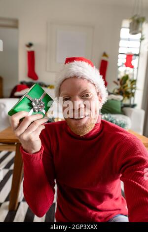 Albino african american uomo che indossa santa Hat fare videochiamata con decorazioni di natale Foto Stock