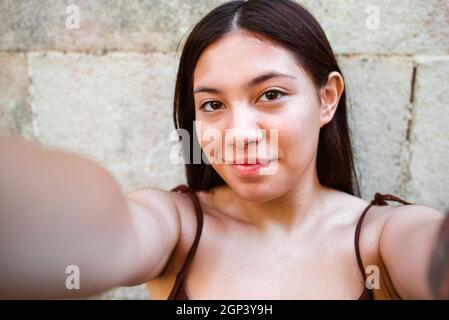 punto di vista prendere di una giovane donna cinese che si prende una foto con il suo smartphone Foto Stock