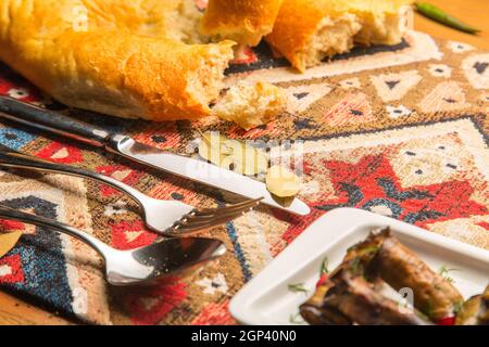 Posate e un pezzo di pane in tovaglie georgiane. Piatto nazionale georgiano fatto in casa. Concetto - menu per un ristorante Foto Stock