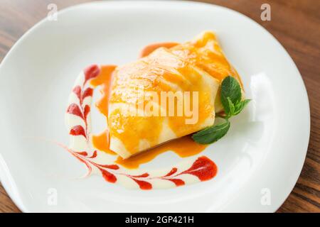 alcuni pancake da dessert con marmellata di fragole, miele e un cucchiaio bianco di gelato. Concetto - menu per un caffè Foto Stock