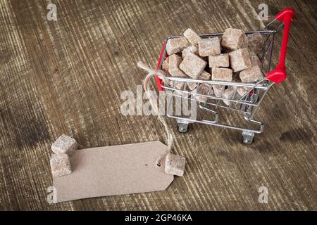 La canna da zucchero Zollette di zucchero nel carrello con carta bianca tag Foto Stock