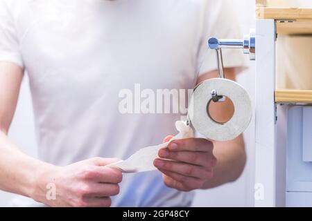 Mano di un maschio che usa carta igienica Foto Stock