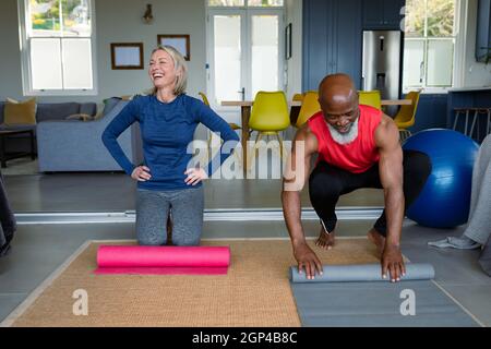 Felice senior diverse coppie in abiti da esercizio che praticano yoga insieme, sorridente Foto Stock