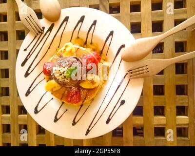 Pancake con frutta e gelato su sfondo grigio, dessert fatti in casa, gustosa colazione Sweet. Foto Stock