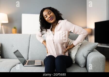 Dolore alla schiena inferiore. Postura errata seduta sul lettino Foto Stock