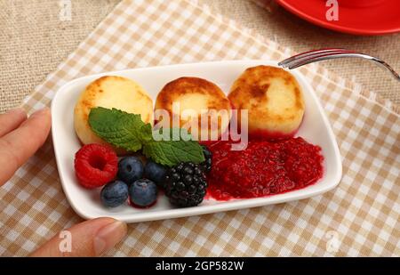 Primo piano mangiare europeo quark formaggio frittelle dessert con frutta, vista dall'alto, direttamente sopra Foto Stock