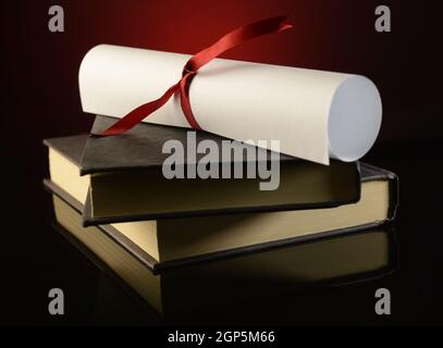 Un diploma in cima a un paio di libri mostra il successo di profitto degli studi scolastici. Foto Stock