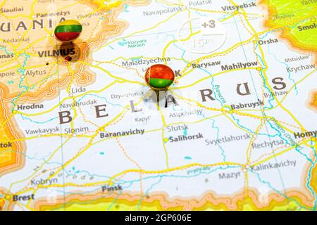 Bandiera nazionale bielorussa fissata sulla carta europea. Macro primo piano immagine del paese su un globo colorato e sfocato della mappa del mondo con fuoco alla capitale di Minsk Foto Stock