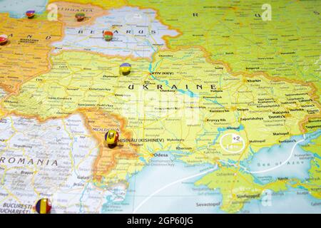 Bandiera nazionale Ucraina ha bloccato sulla mappa politica dell'Europa. Macro primo piano su un atlante del mondo colorato e sfocato con attenzione al paese capitale - Kiev Foto Stock