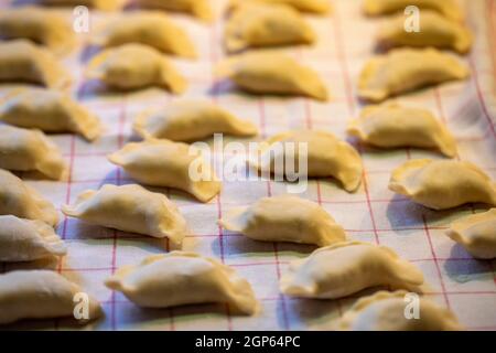 I gnocchi sono fatti a mano. Gnocchi grezzi ripieni di carne in linea nella cucina casalinga Foto Stock