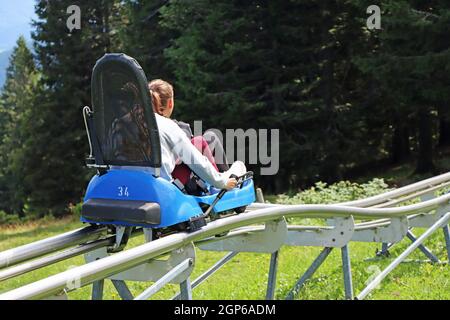 Due giovani ragazze che si divertono in estate sulle montagne russe alpine a Rogla, Slovenia Foto Stock