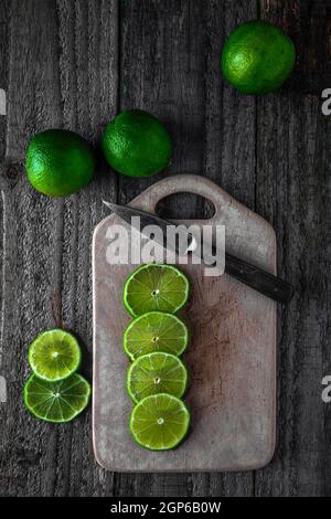 Fette di lime tagliate sul tagliere Foto Stock