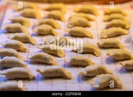 I gnocchi sono fatti a mano. Gnocchi grezzi ripieni di carne in linea nella cucina casalinga Foto Stock