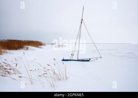 Festgeforenes und eingeschneites Segelboot am Saaler Bodden, Fischland-Darß Foto Stock