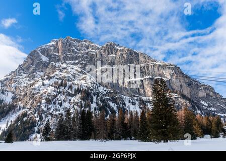 Picco roccioso coperto di neve nelle Alpi europee in una limpida giornata invernale. Una stazione della funivia è visibile sulla cima della montagna. Foto Stock