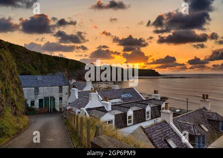 Vista di case residenziali e hotel sul mare, tramonto, Pennan, Aberdeenshire, Scozia, Regno Unito Foto Stock
