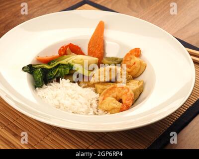 Curry thai rosso con pollo e gamberi con verdure fritte e riso, concetto di cibo sano Foto Stock