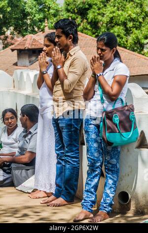 KANDY, SRI LANKA - 19 LUGLIO 2016: Pellegrini buddisti bianchi vestiti pregano a Wel Bodiya con l'albero Bodhi durante la vacanza Poya (Luna piena) a Kandy, Sri LAN Foto Stock