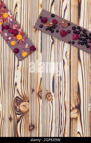 diversi tipi di cioccolato con frutta secca su tavola di legno Foto Stock