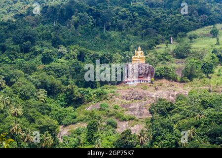 Statua di Buddha su un pendio collinare vicino al Tempio di Aluvihare Rock, Sri Lanka Foto Stock