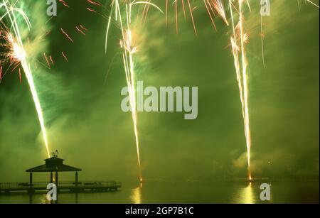 Fuochi d'artificio al Delco Park. Molo di pesca e la silhouette del padiglione in primo piano dei fuochi d'artificio esposti al suolo. Delco Park, Kettering, Dayton, Ohio, Stati Uniti. Foto Stock