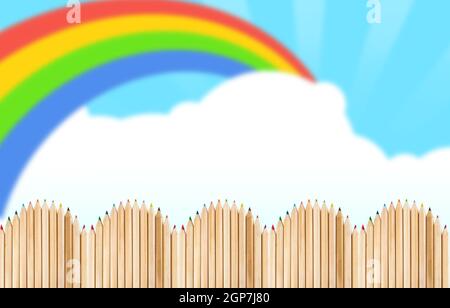 Recinzione fatta con matite di legno sul cielo blu con rainbow Foto Stock