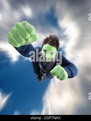 Il supereroe verde con pugno spinta in avanti volare nel cielo Foto Stock