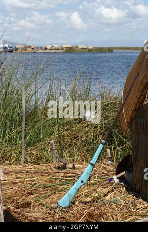 Isole galleggianti fatte di canne della gente di Uros che vive sul lago Titicaca, Perù, Sudamerica. Ecco una pistola usata dagli isolani per la caccia. Foto Stock