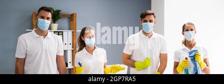 Giovane Commercial Cleaning Team persone in maschera facciale Foto Stock