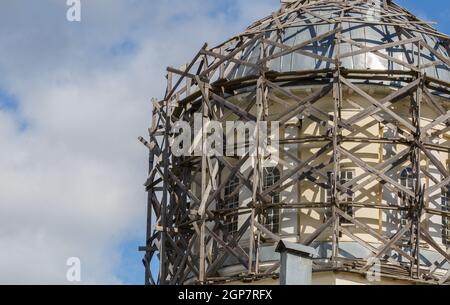 ponteggi in legno grigio su cupola architettonica al giorno luce su cielo blu con nuvole bianche Foto Stock