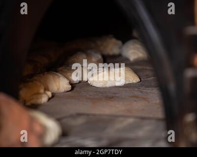 La produzione giornaliera di pane cotto con forno a legna con il metodo tradizionale. Foto Stock