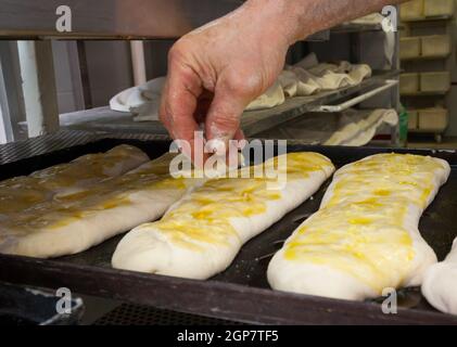 La produzione giornaliera di pane cotto con forno a legna con il metodo tradizionale. Foto Stock