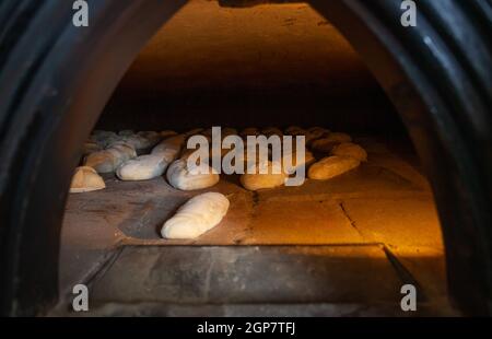 La produzione giornaliera di pane cotto con forno a legna con il metodo tradizionale. Foto Stock